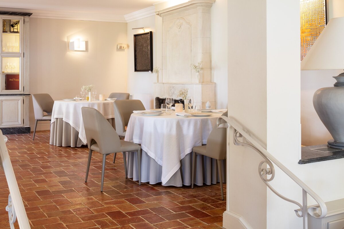 A dining room with white tables and chairs