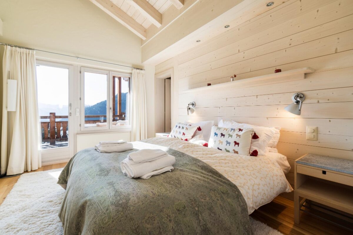 A bedroom with a bed and pillows with sheep on them
