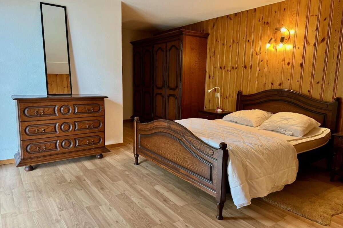 A bedroom with a bed dresser and a mirror