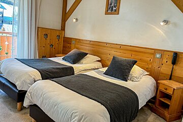 A hotel room with two beds and a picture on the wall