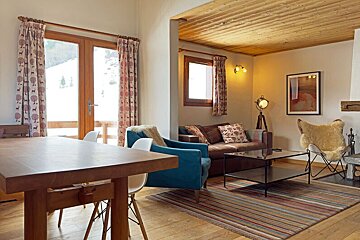 A living room with a fireplace and a clock on the wall that shows the time as 10:10
