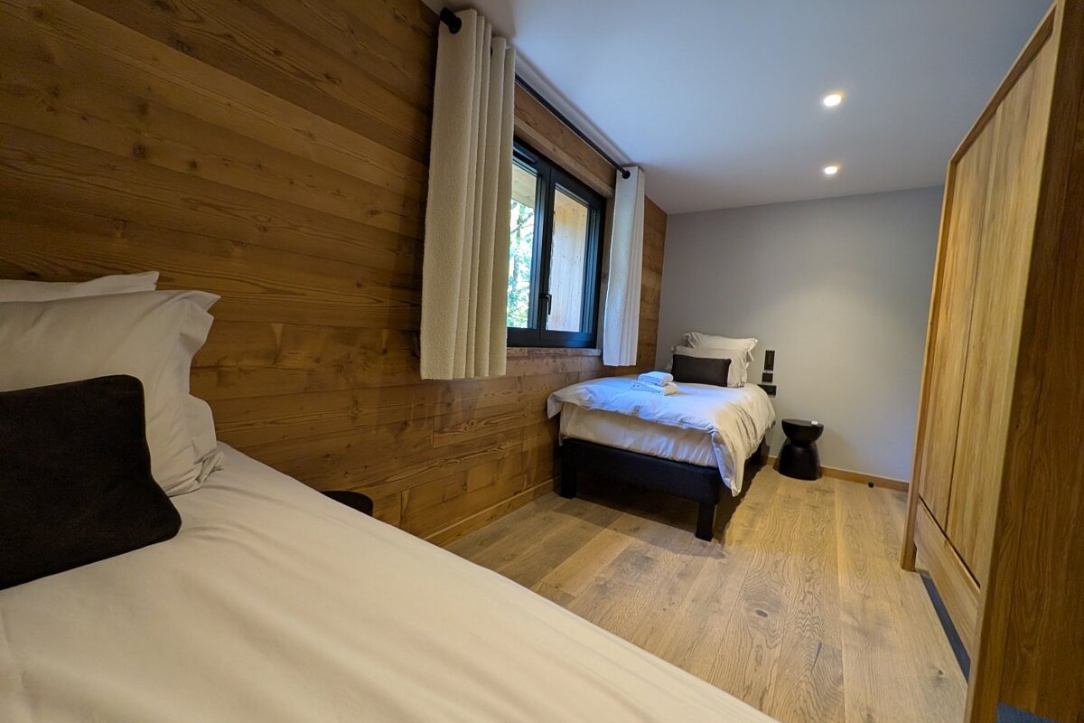 A bedroom with two beds and a window