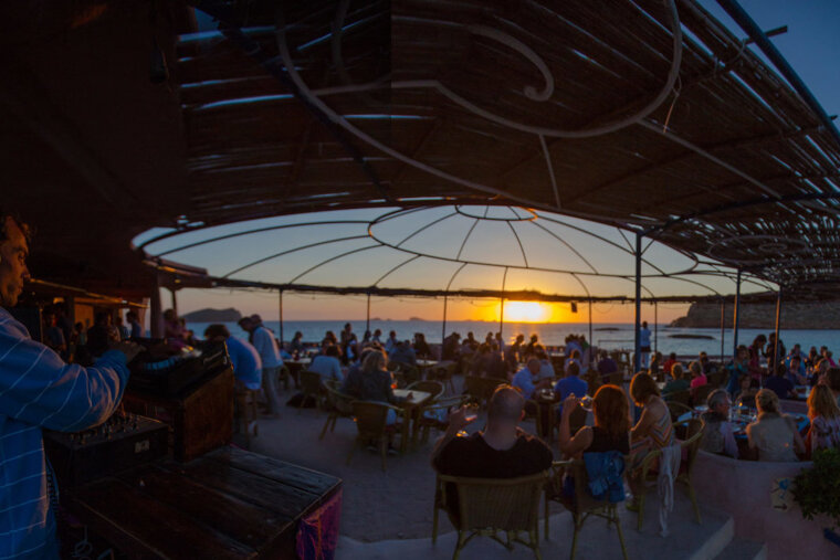 A man playing music in front of a crowd at sunset