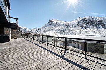 A balcony with a view of snow covered mountains