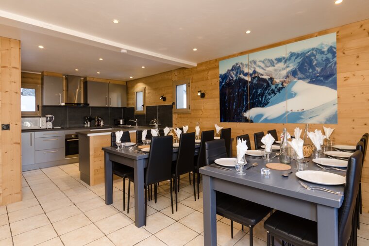 A dining room with a picture of mountains on the wall
