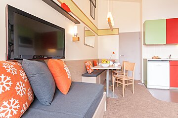 A living room with a couch and a flat screen tv