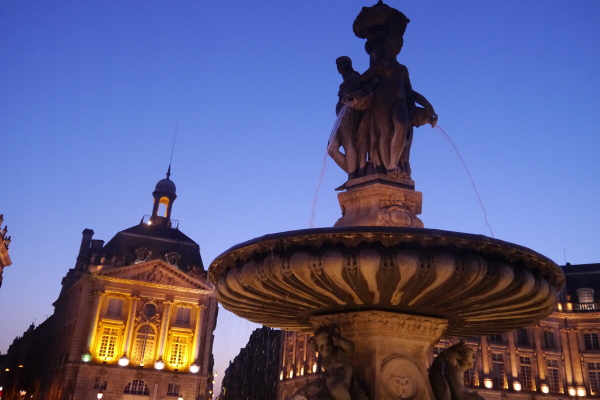 a night shot of a fountain in bordeaux