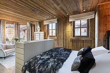 A bedroom with a fur blanket on the bed