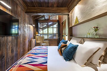 A bedroom with a warning sign on the wall above the bed