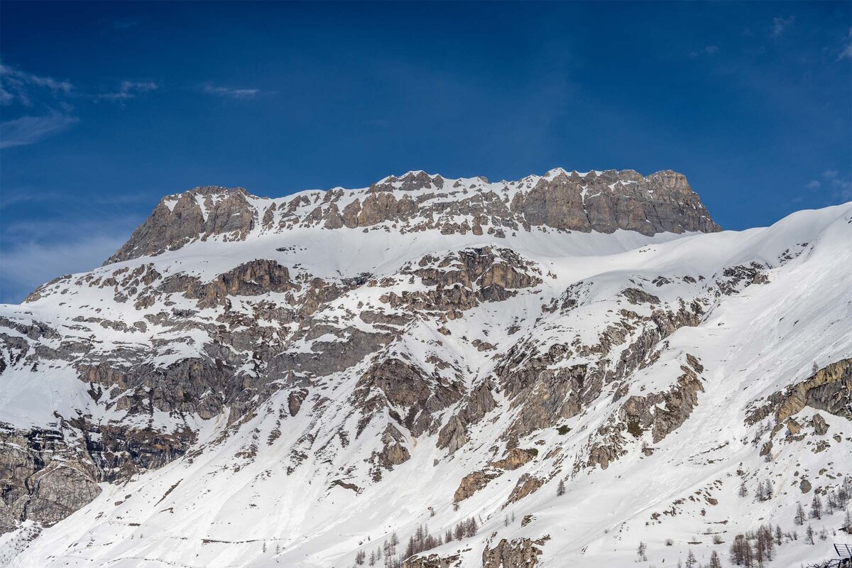 A snowy mountain with a blue sky in the background