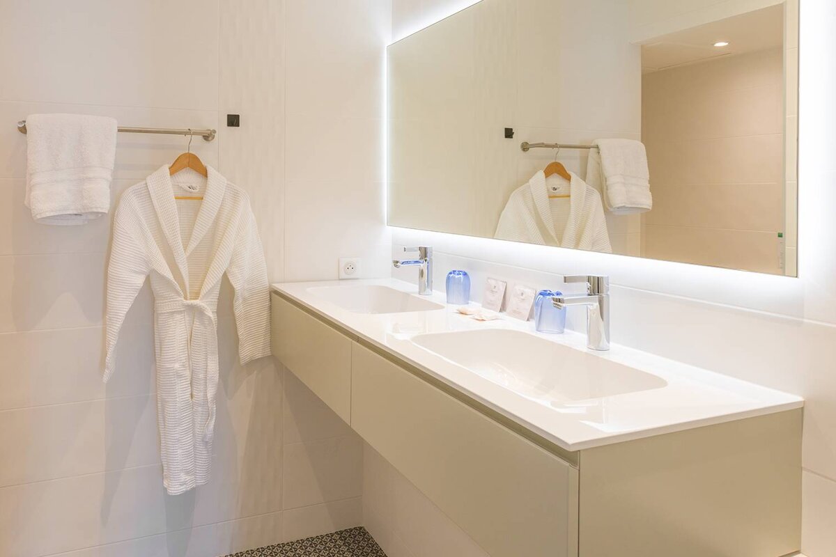 A bathroom with two sinks and a large mirror