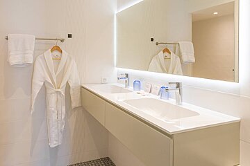 A bathroom with two sinks and a large mirror
