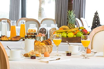 A table with a variety of food and drinks including orange juice