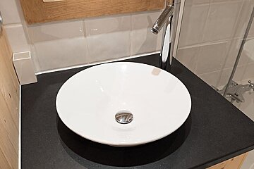 A bathroom sink with a black counter top