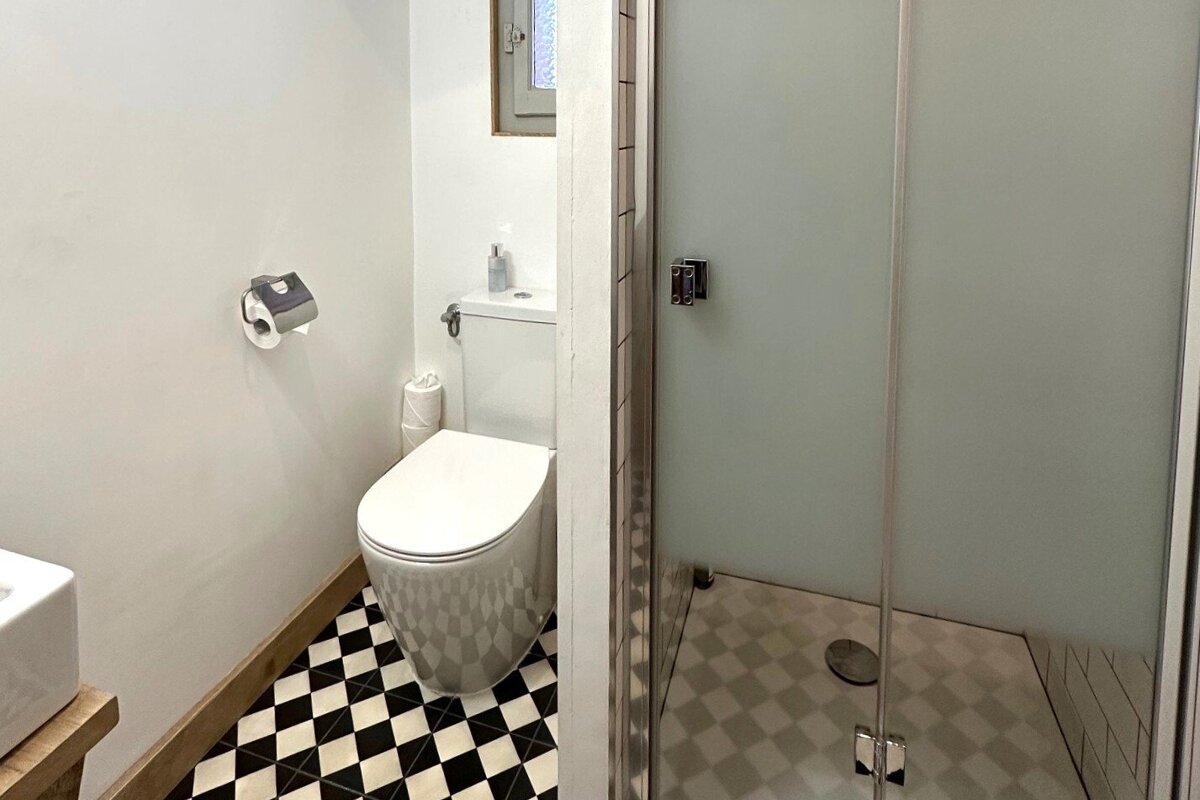 A bathroom with a black and white checkered floor and a toilet