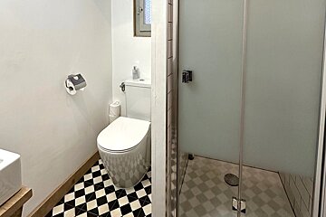 A bathroom with a black and white checkered floor and a toilet