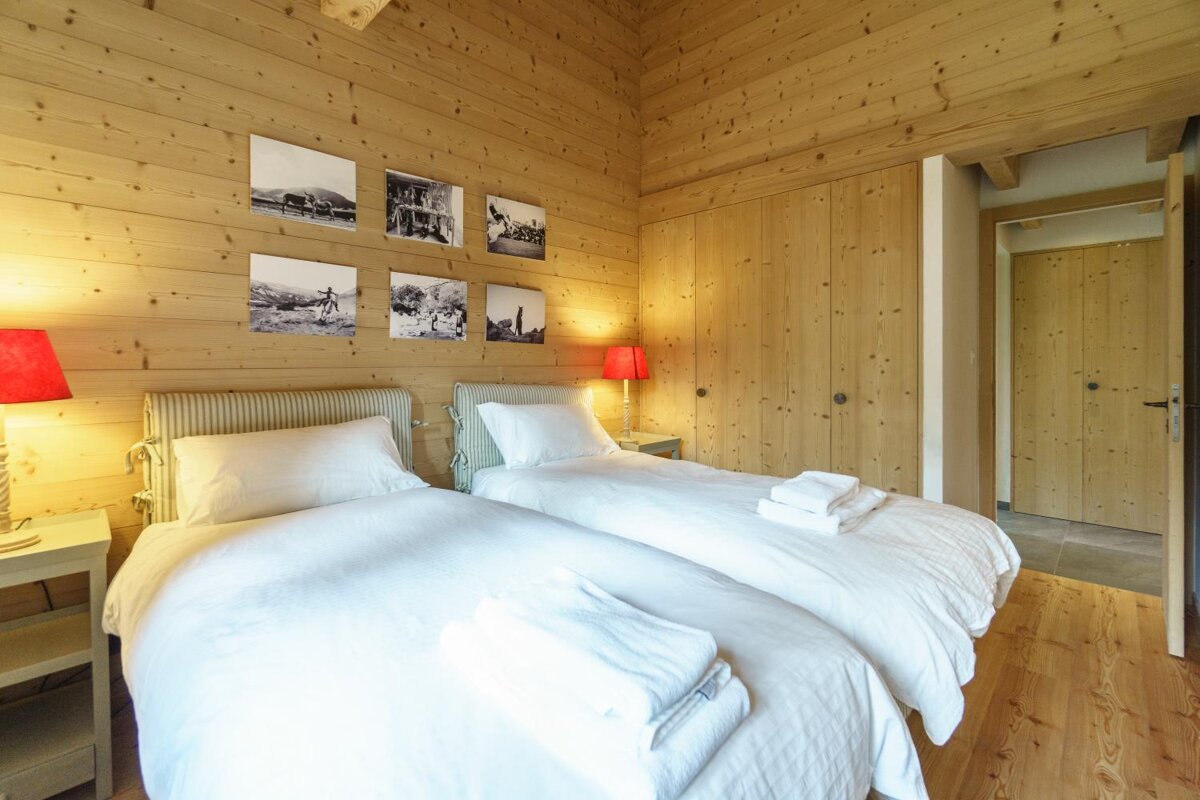 A bedroom with two beds and pictures on the wall