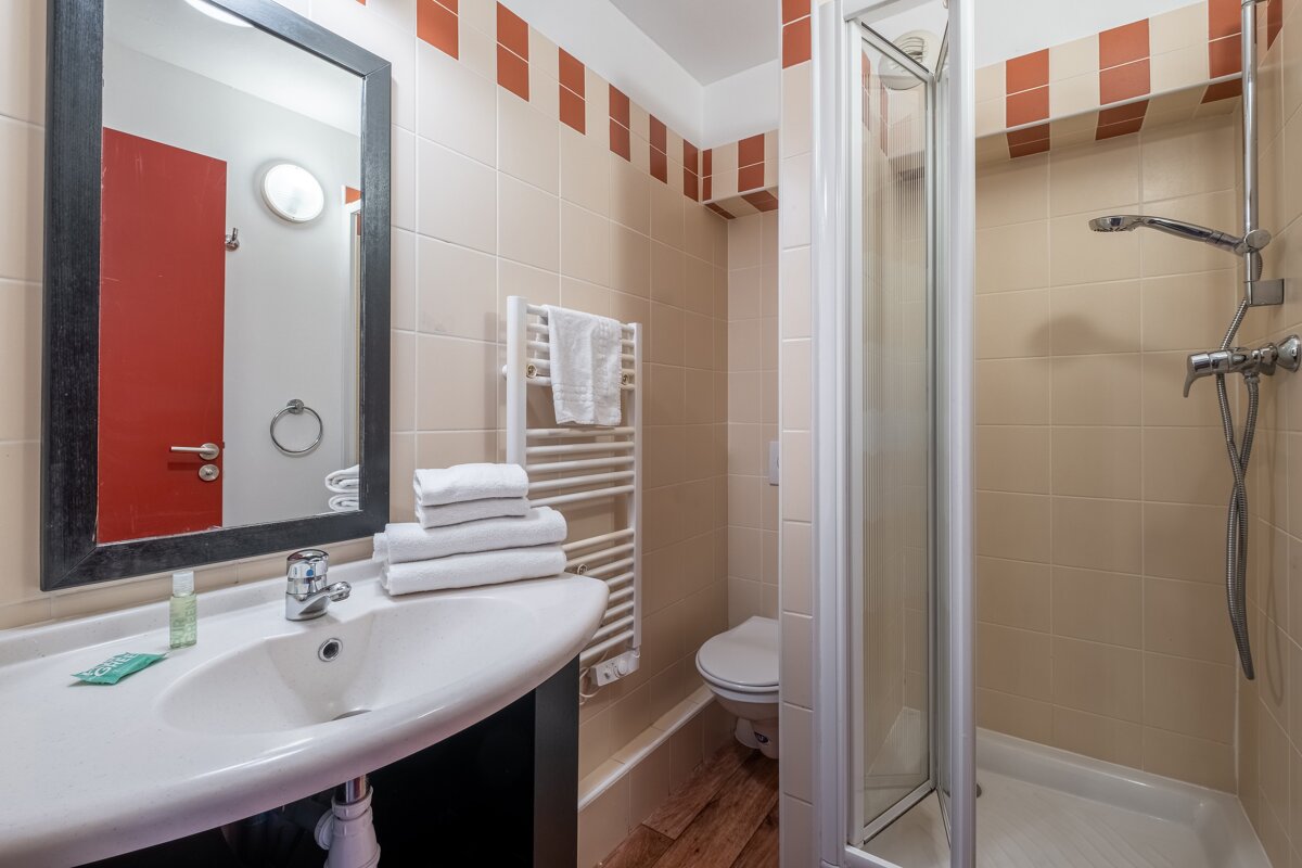 A bathroom with a toilet a sink and a mirror