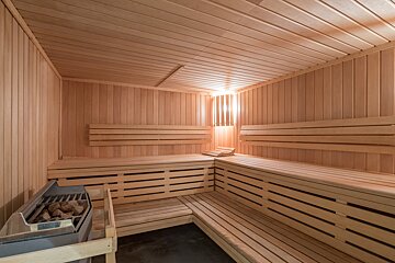 A wooden sauna with a heater in the corner