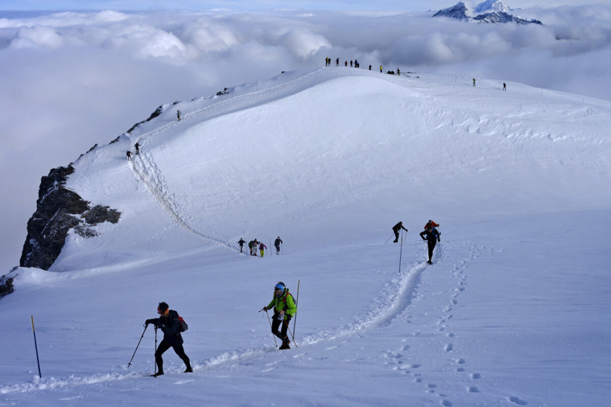 A group of people hiking up a snowy mountain
