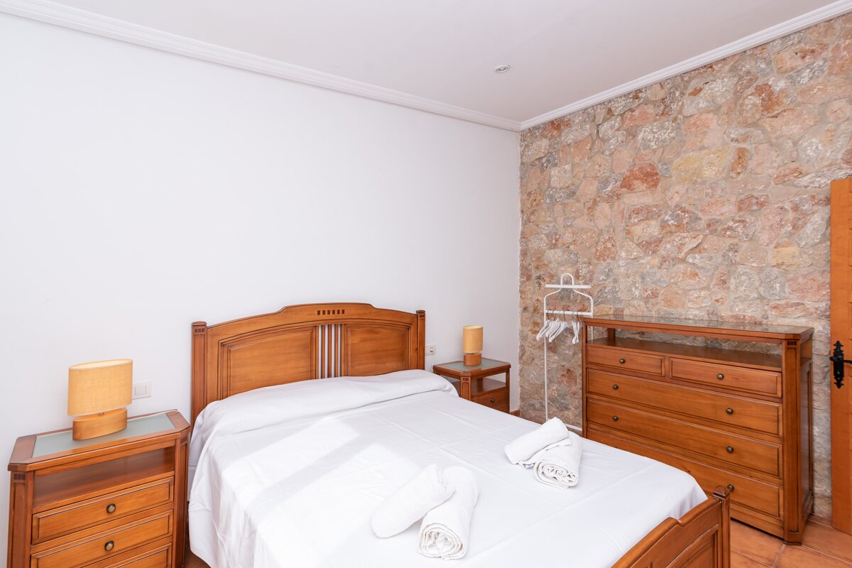 A bedroom with a wooden bed and a dresser