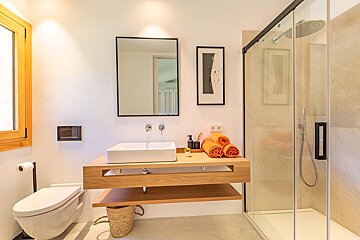 A bathroom with a toilet a sink and a shower