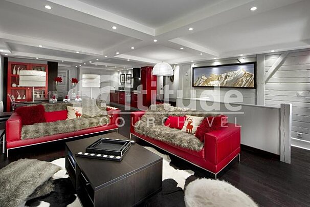 A living room with a red couch and a black coffee table
