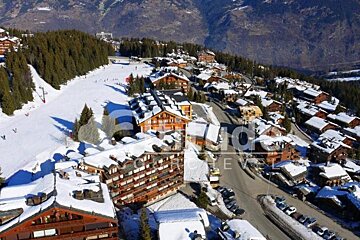 An aerial view of a snowy ski resort with the word studios visible