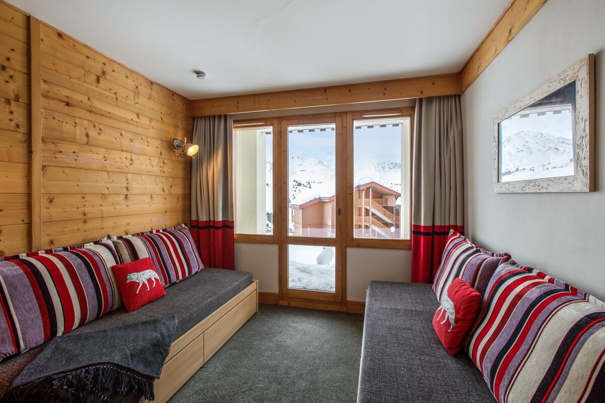 A room with a couch and a pillow with a wolf on it