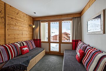 A room with a couch and a pillow with a wolf on it