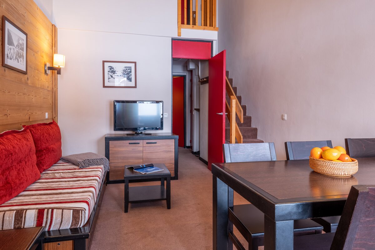 A living room with a couch a table and a television