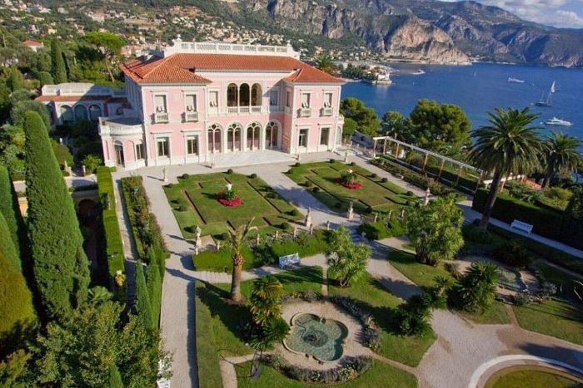 An aerial view of a large house with a large garden in front of it