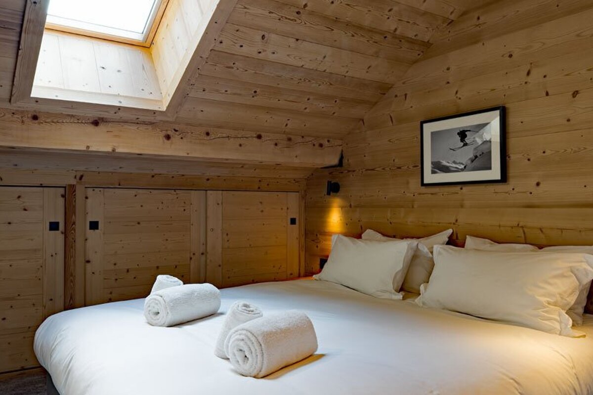 A bedroom with a picture of a skier on the wall above the bed