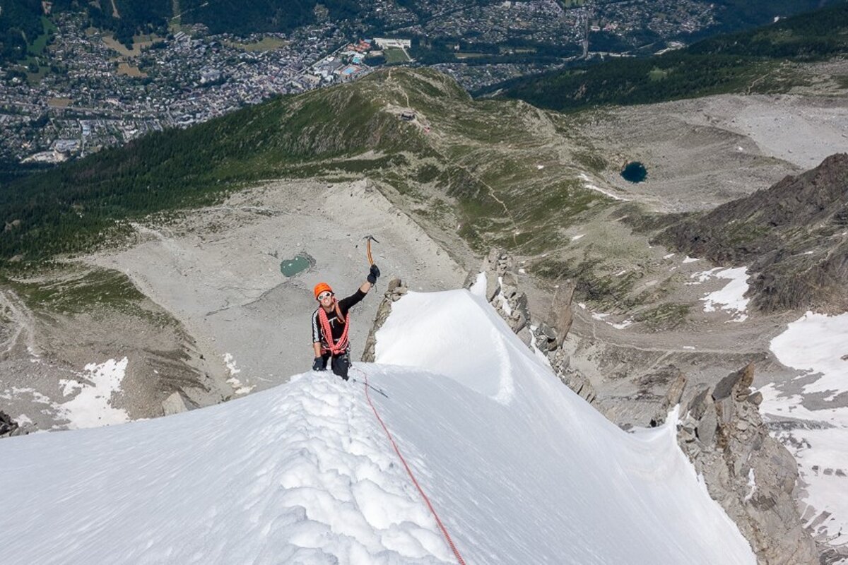 A person on a snowy mountain with a city in the background