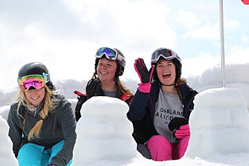 three skiers in a snow castle