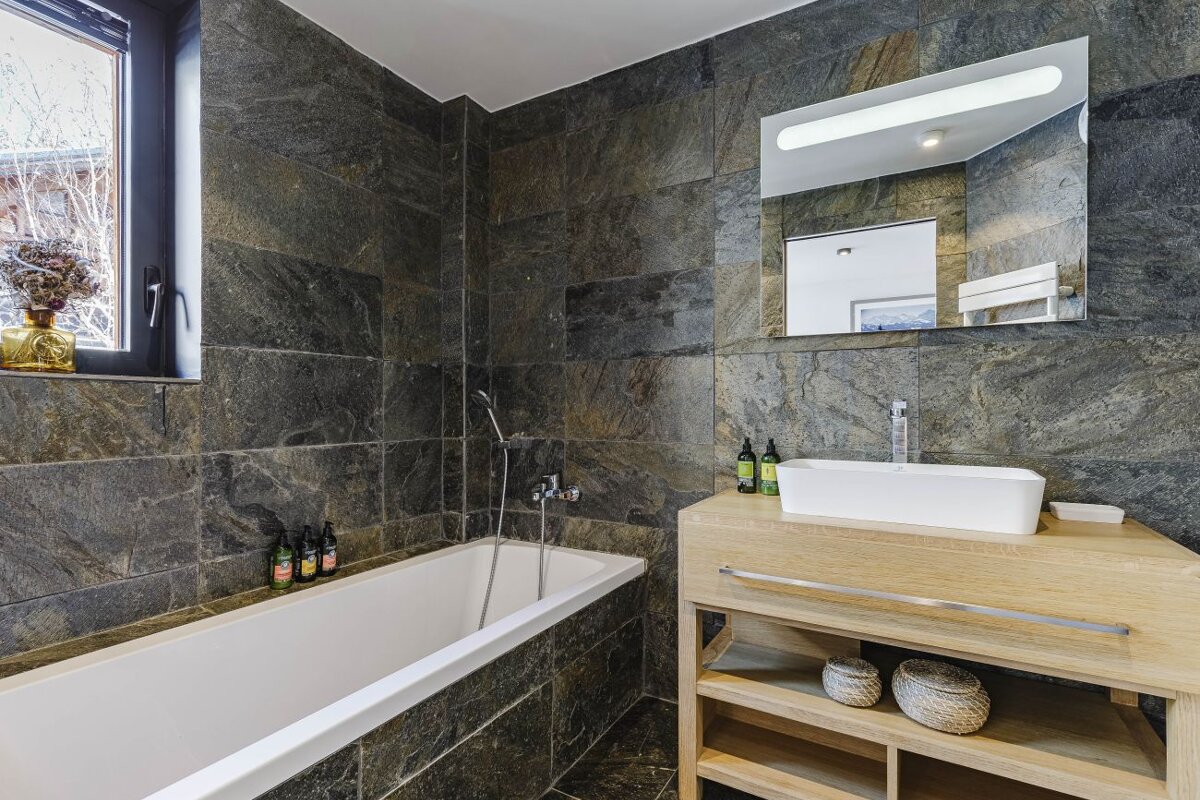 A bathroom with a bathtub sink and mirror