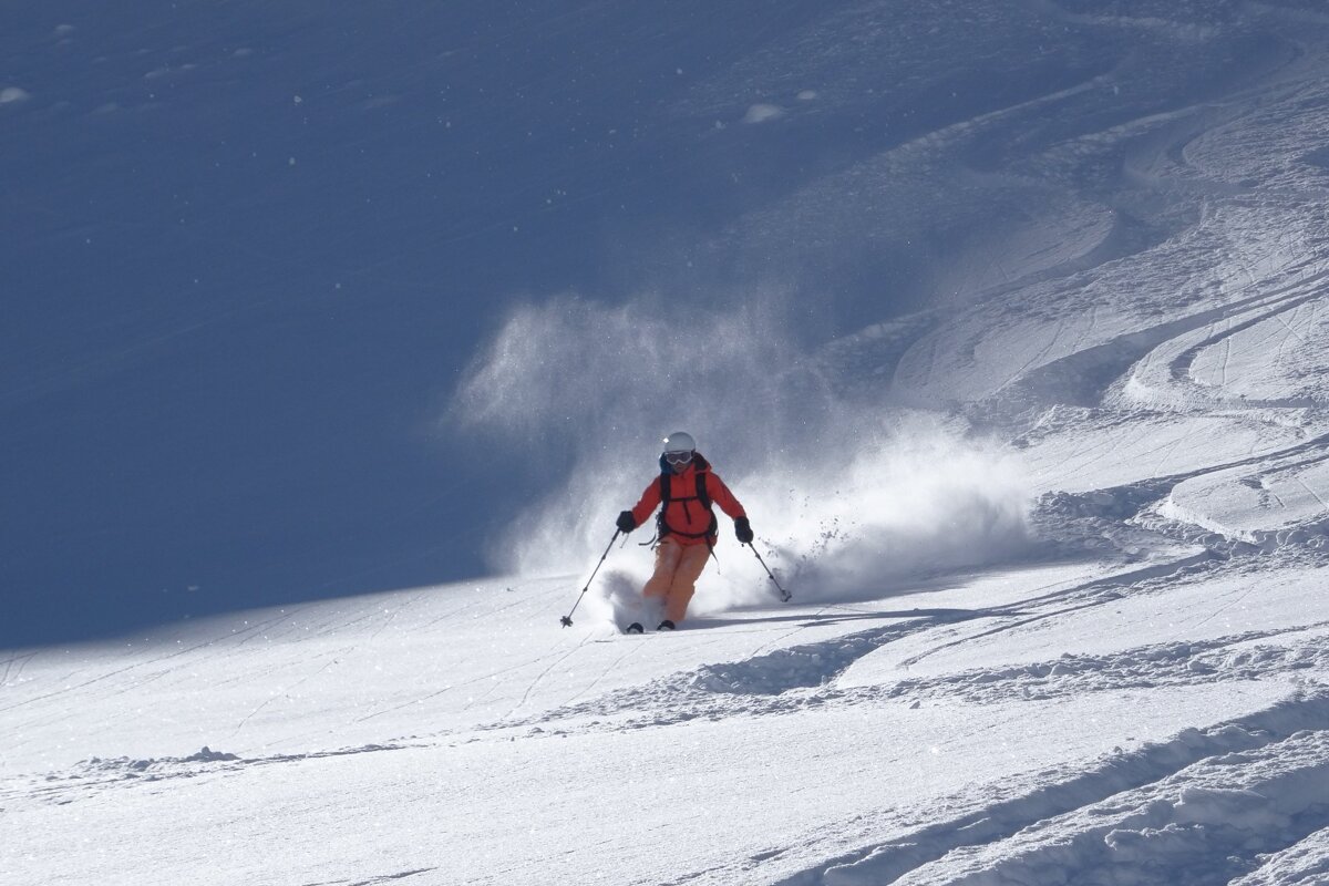 A person is skiing down a snow covered slope