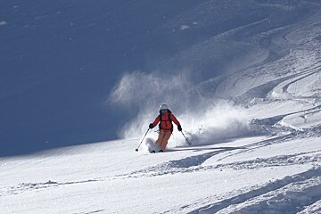 A person is skiing down a snow covered slope