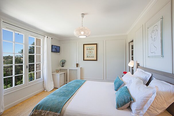 A bedroom with a bed and a picture on the wall