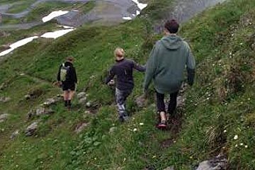 three people walking down a mountain path in avoriaz