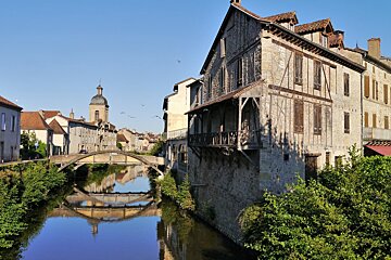 a river with bridge and some houses in saint cere