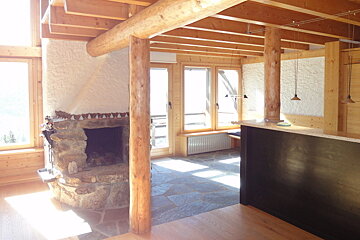 A room with a stone fireplace and a black counter