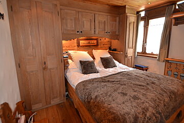 A bed with a fur blanket and pillows in a bedroom