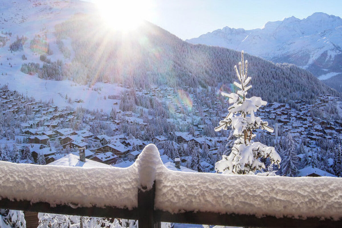 A snowy landscape with mountains in the background