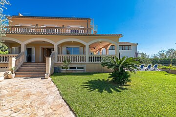 A large house with a lush green lawn in front of it