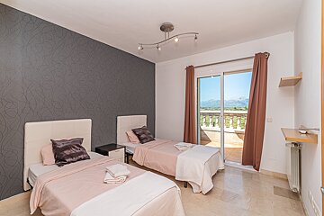 A bedroom with two beds and a sliding glass door