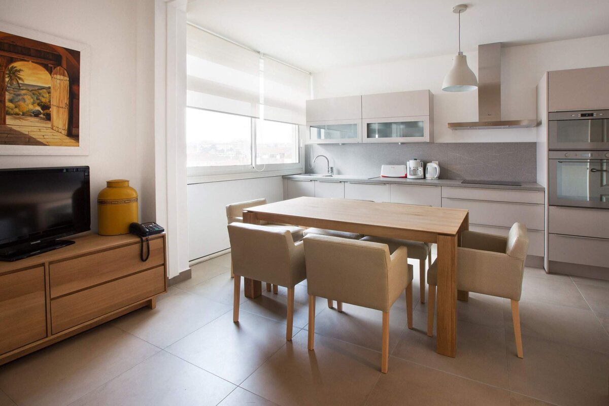 A kitchen with a table and chairs and a tv