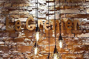 A brick wall with a sign that says le grenier