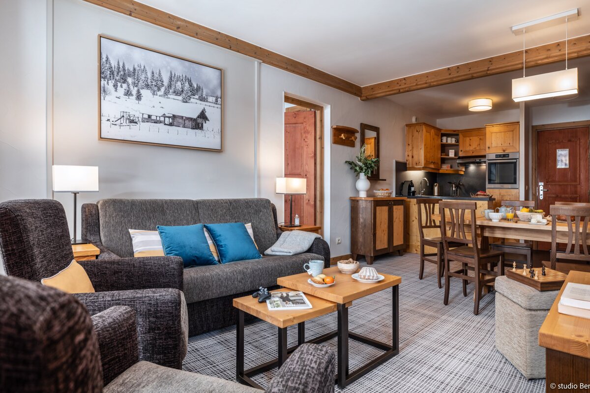 A living room with a couch and chairs and a painting on the wall