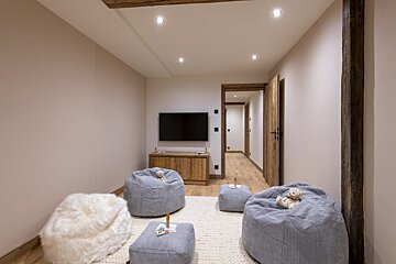 A room with bean bag chairs and a flat screen tv
